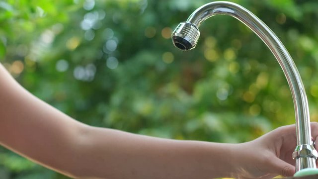 4k hand open faucet to take water in the garden