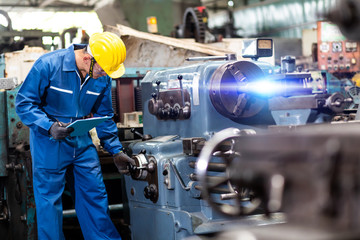 Mechanical Engineering control lathe machine in factory facility. Safety First at work place.