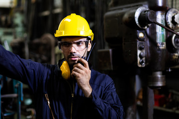 Portrait of factory worker and engineer at industrial facility. Construction worker in hardhat and...