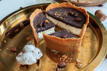 Cheesecake on a golden tray with Asai palm fruits and caramel.