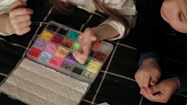 child plays with perler beads. fine motor development