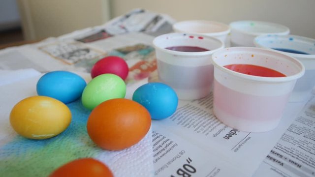 Freshly painted colorful Easter eggs on the table on the newspaper