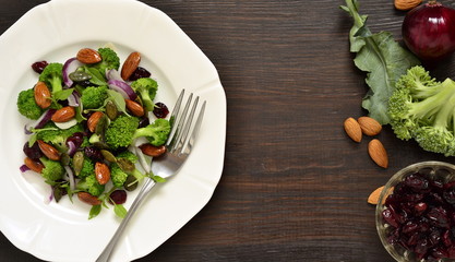 Broccoli salad with red onions, almonds and dried cranberries, top view, copy space