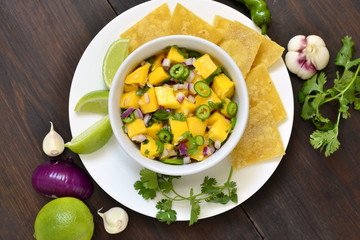 Homemade Mango Salsa with Ingredients and Corn Chips, top view 