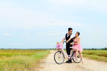 Fototapeta na wymiar Asian bride and groom on the bicycle