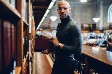 Contemplative caucasian male professor in stylish optical spectacles for provide eyes protection...