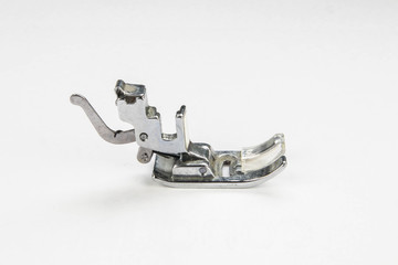 Metal sewing machine foot isolated on a white background.  Close up macro