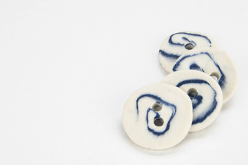 Selection of artisan handmade ceramic buttons isolated on a white background.  Close up macro