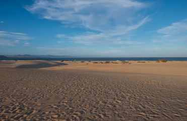Fototapeta na wymiar Ripples on sand dune near Corralejo with volcano mountains in the background, Fuerteventura, Canary Islands, Spain. October 2019
