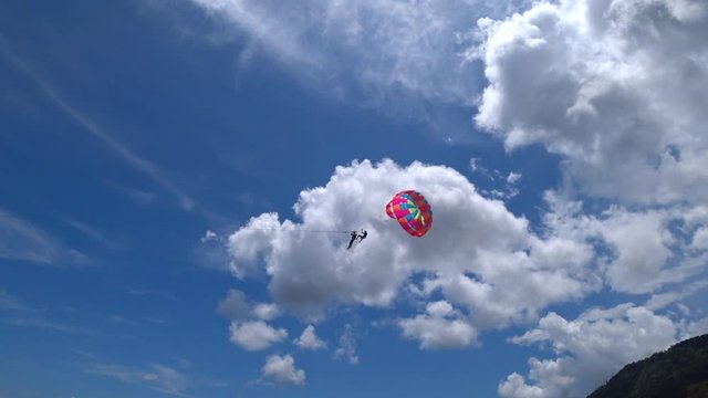 Parasailing in Patong beach, flying over, famous beach that full of tourists and lot of activities, located in Phuket, Thailand.