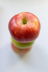Three apples, one green and two red-yellow on a light background.