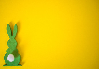 Green Easter bunny on yellow background. Easter holidays yellow background