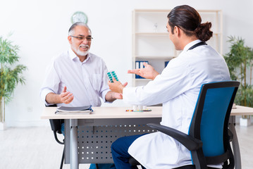 Obraz premium Old man visiting young male doctor