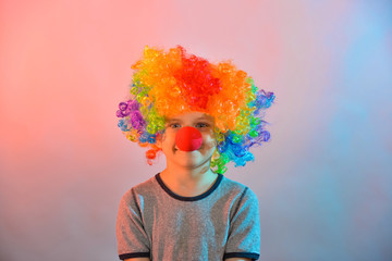 Joyful child in a clown wig looks at the camera.