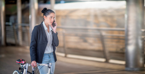 businesswoman talking to a teammate on the phone to work on a bicycle