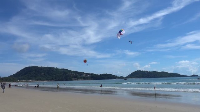 Parasailing in Patong beach, famous beach that full of tourists and lot of activities, located in Phuket, Thailand.