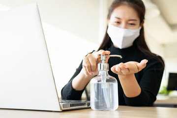 Woman wearing face mask protective for spreading of disease virus SARS-CoV-2 and hand wash cleaning by alcohol gel in office working for protection bacteria and virus, Covid-19 Coronavirus concept