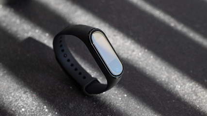 black electronic watch and smart fitness tracker at textured black background. dark object at dark background. dark luxury mood. fashionable accessory.