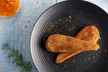 Seasoned chicken with hot sauce and a sprig of rosemary