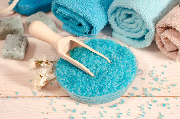 spa wellness cosmetic organic products sea salt. Sea salt, towels and flowers on yellow background. Selective focus. Flat lay with copy space.