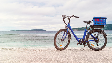 Tourist bicycle by the beach, no people.