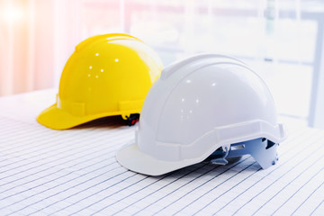 Helmet placed on a white table, White and  yellow hard safety helmet hat for safety project of workman as engineer or worker, Safety concept.