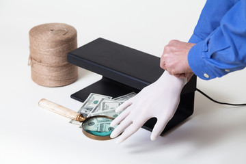 Hands putting on rubber gloves for working with money