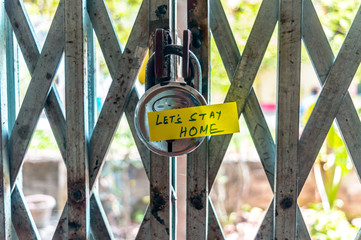 Let’s stay home sticker on door lock gate. Stay at home order during self-quarantine and Lockdown at home. Practice social distancing during State of Emergency on coronavirus pandemic COVID outbreak