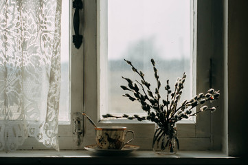 a Cup of tea and willow twigs on the windowsill