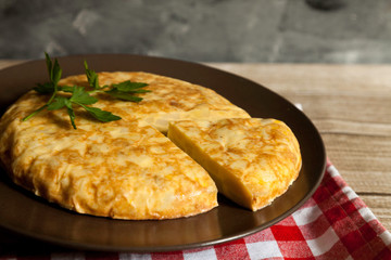 Spanish omelette and portion in a plate with napkin
