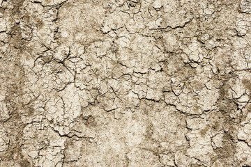 Dry ground cracked background. Soil after drought pattern. Cracks on sandy earth texture. Lack of water on globe problem background. Brown grunge dust backdrop.