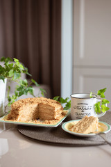 Honey cake. A cup of coffee. Tasty breakfast. A slice of cake with white cream, cream. Honey. Honey recipe.