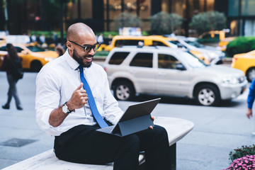 Black smiling manager looking at tablet screen