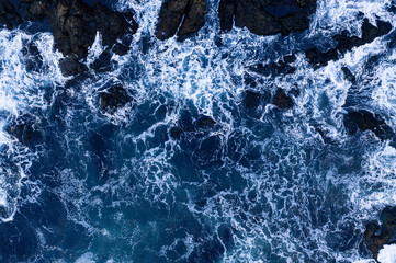Top down view of giant ocean waves crashing and foaming