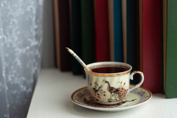 a Cup of tea and books on the windowsill