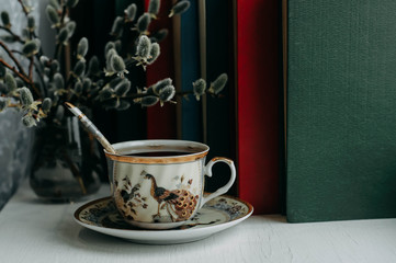 a Cup of tea, books and willow branches on the windowsill
