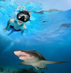 Fototapeta premium Young girl swimming with sharks.