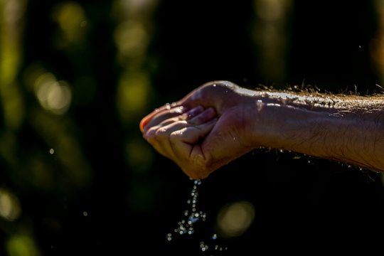 Hands With Water Splash, Backlit By The Evening Sun.