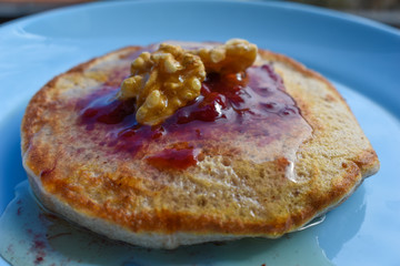 Pancakes with maple syrup, walnuts and red fruit jam.