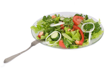 Vegetable salad on a plate with a fork on a white background