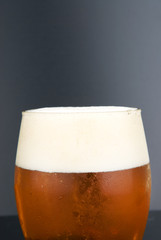 Foggy glass with cold beer on a black background