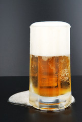 Foggy glass with cold beer on a black background