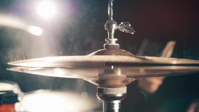 Drummer, drumset, drums in slow motion Metal drum cymbals with water.