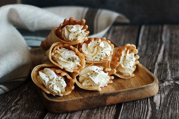 Russian waffles with cream cheese and spices. Wafer rolls on the table. Delicious waffles