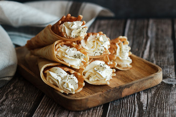 Russian waffles with cream cheese and spices. Wafer rolls on the table. Delicious waffles