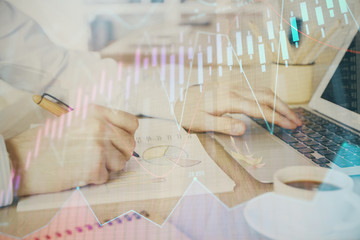 Multi exposure of stock market graph with man working on laptop on background. Concept of financial analysis.