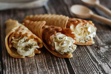 Russian waffles with cream cheese and spices. Wafer rolls on the table. Delicious waffles