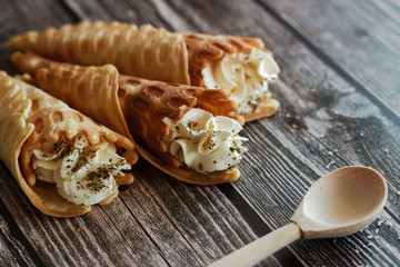 Russian waffles with cream cheese and spices. Wafer rolls on the table. Delicious waffles