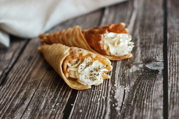 Russian waffles with cream cheese and spices. Wafer rolls on the table. Delicious waffles