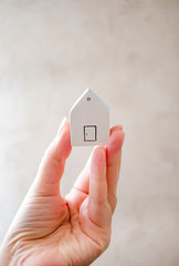 hand holding a house.Stay at home during coronavirus.  Homeless need home. Buy house. House for rent.